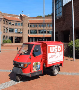 Die USD-Ape mit Wahlwerbung vor dem Rathaus in Hamminkeln – Symbol für bürgernahe Politik und Sichtbarkeit der USD zur Kommunalwahl 2025.
